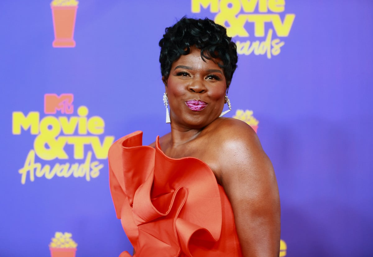 Leslie Jones smiling in front of a purple background
