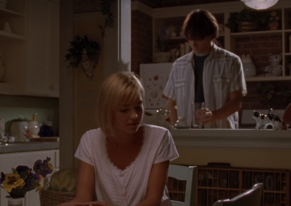 Dean Forrester stands at the counter of his apartment while his wife, Lindsay Lister, sists at the Kitchen table in an episode of 'Gilmore GIrls' 