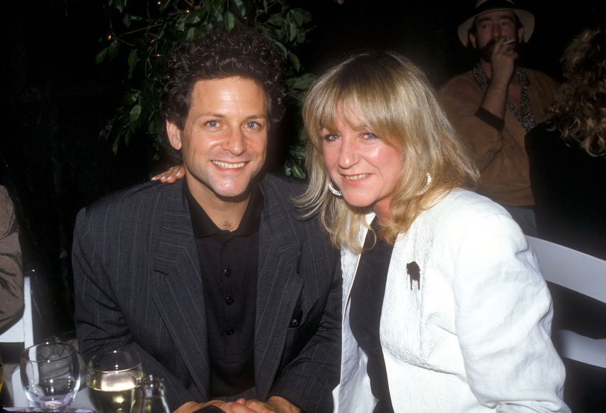 Fleetwood Mac stars Lindsey Buckingham and Christine McVie smile and pose together at an event.