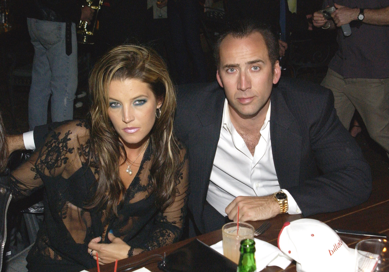 Lisa Marie Presley and Nicolas Cage sitting next to each other against a dark background