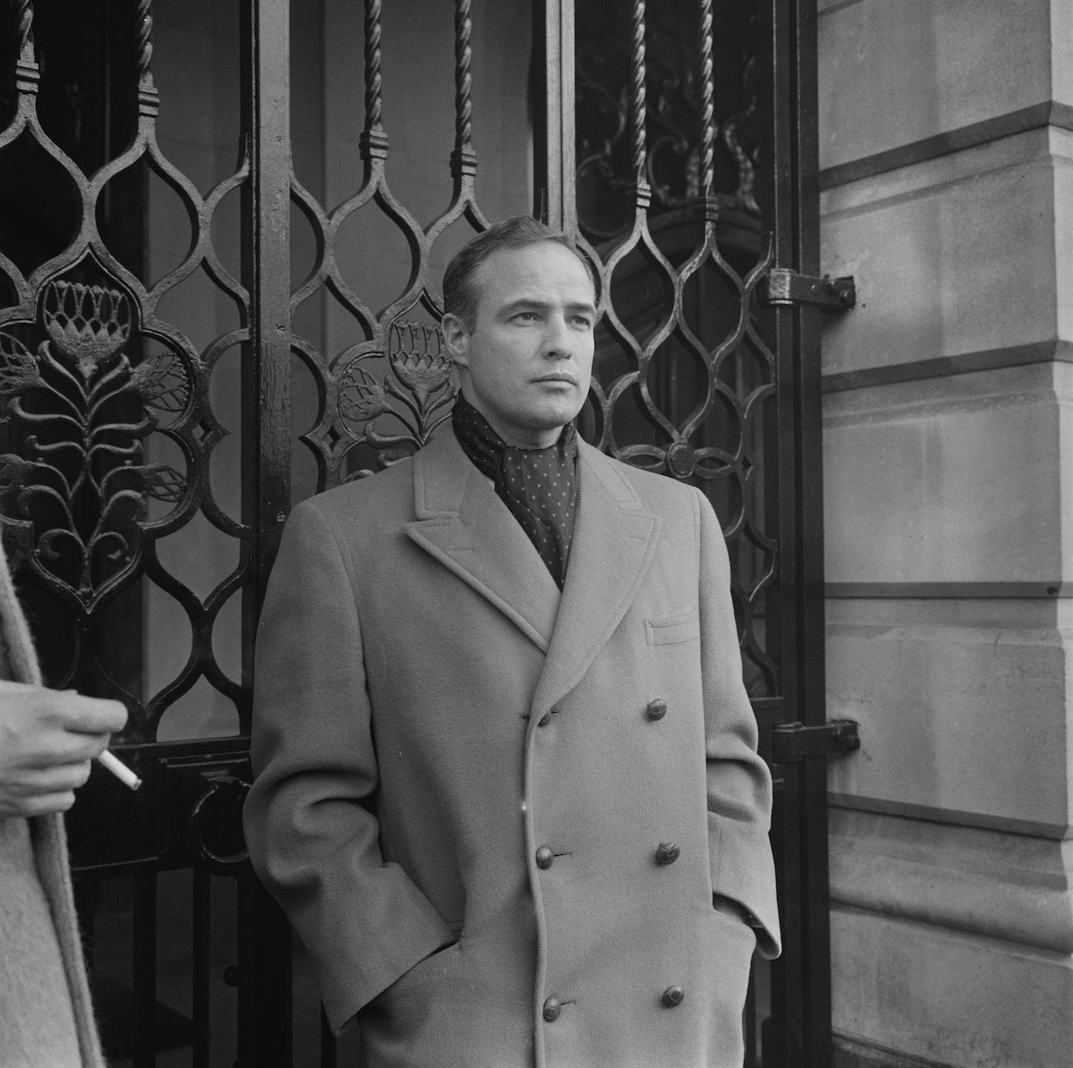 Marlon Brando appears in a long coat in a black and white photo