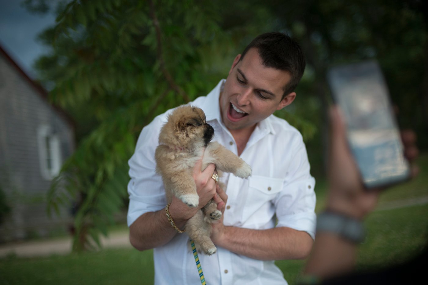 Matt Fraser from the new show 'The Frasers + ONE' holds a puppy and smiles 
