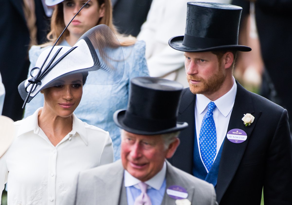 Meghan Markle and Prince Harry, who a commentator says will have the final say in attending coronation of King Charles, walk behind King Charles III