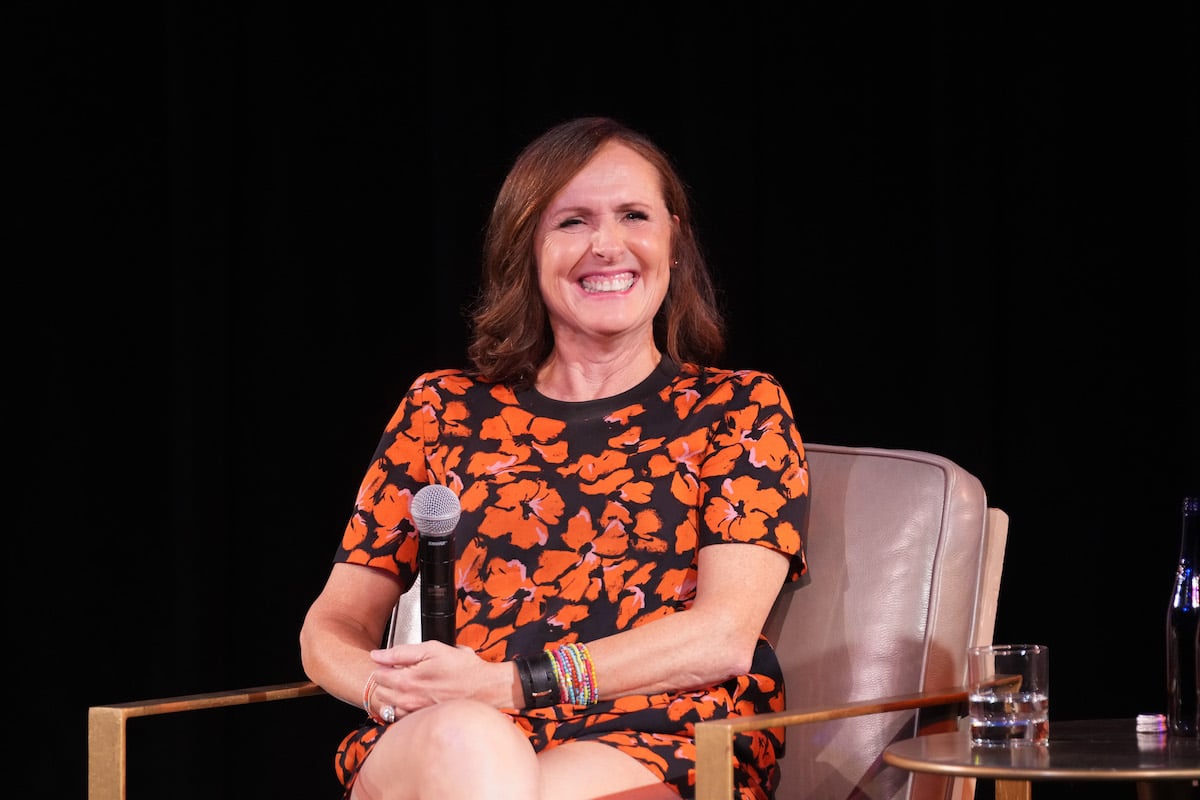 Molly Shannon speaks onstage during the 2022 New Yorker Festival in an orange floral dress