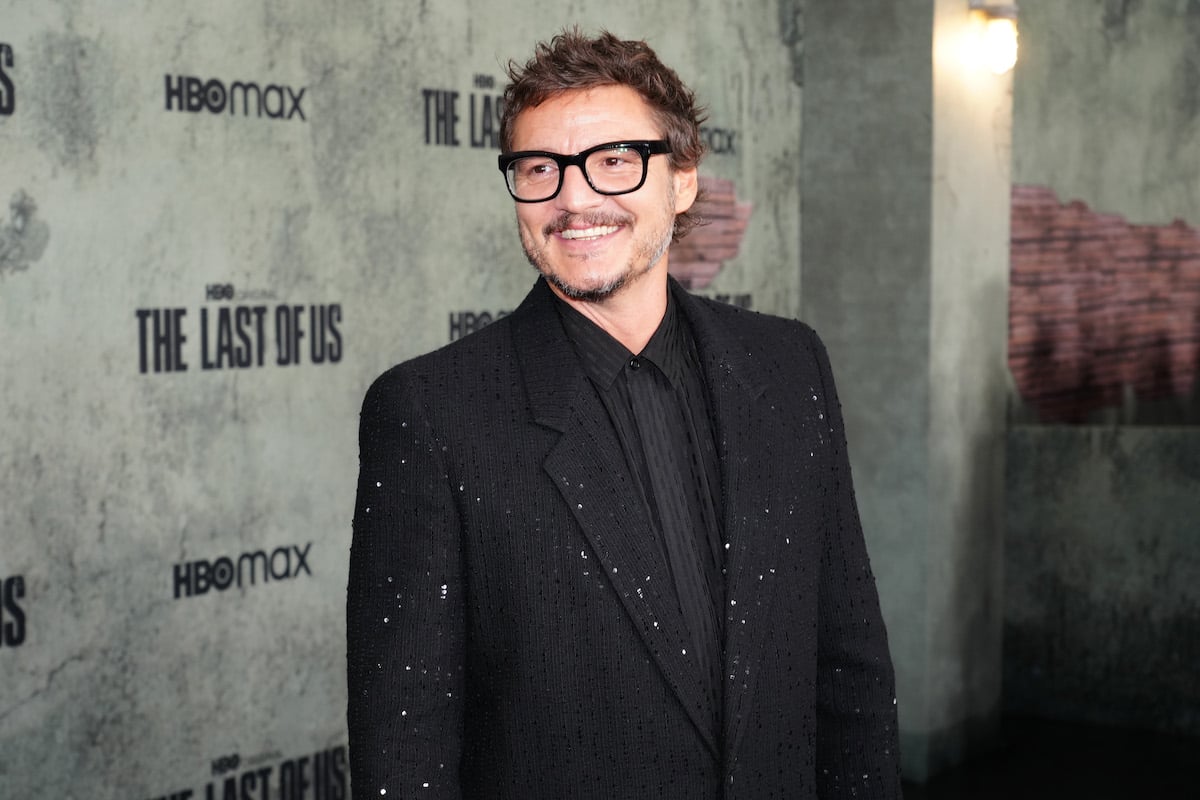 Pedro Pascal poses in front of a backdrop featuring "The Last of Us" series logo