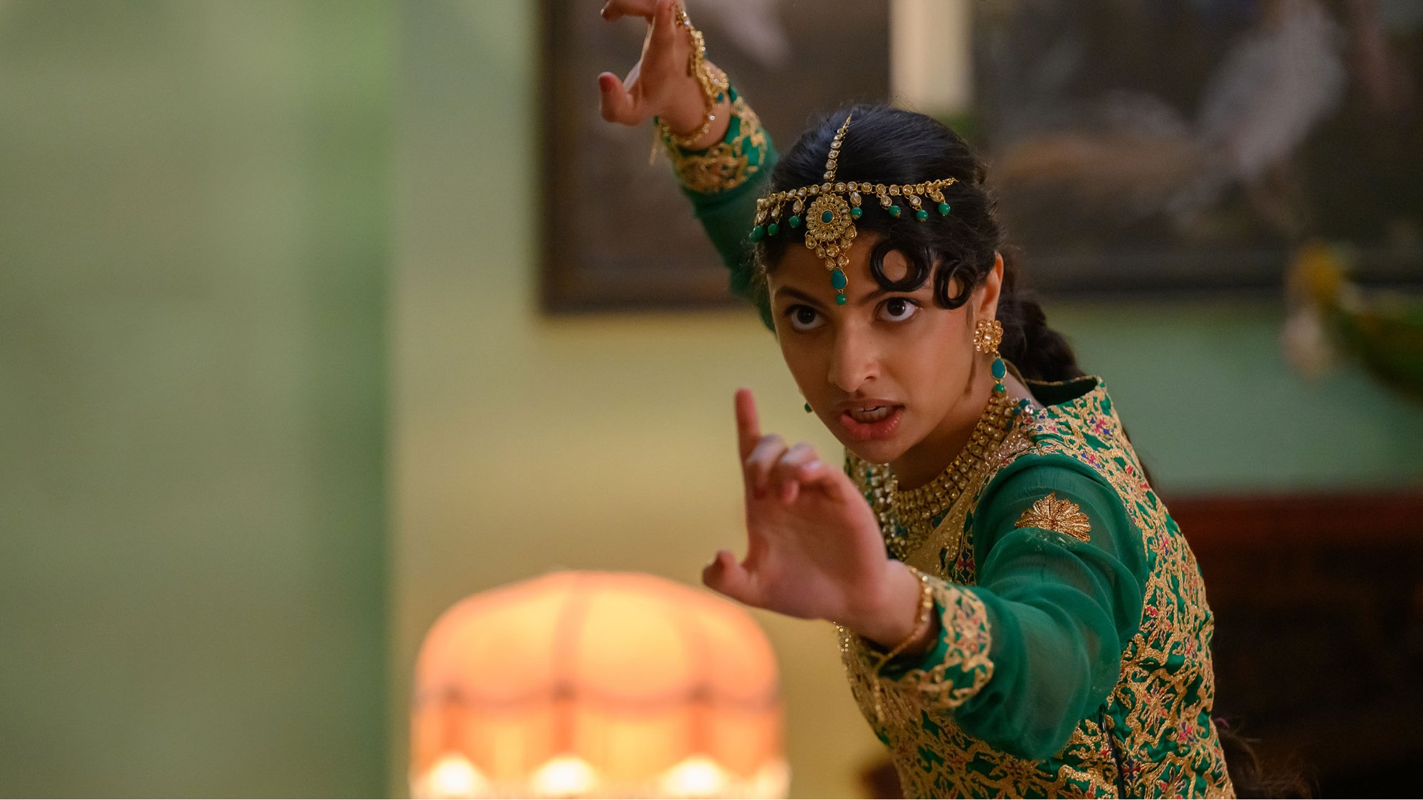 'Polite Society' Priya Kansara as Ria Khan in a fighting pose, wearing a green and gold dress.