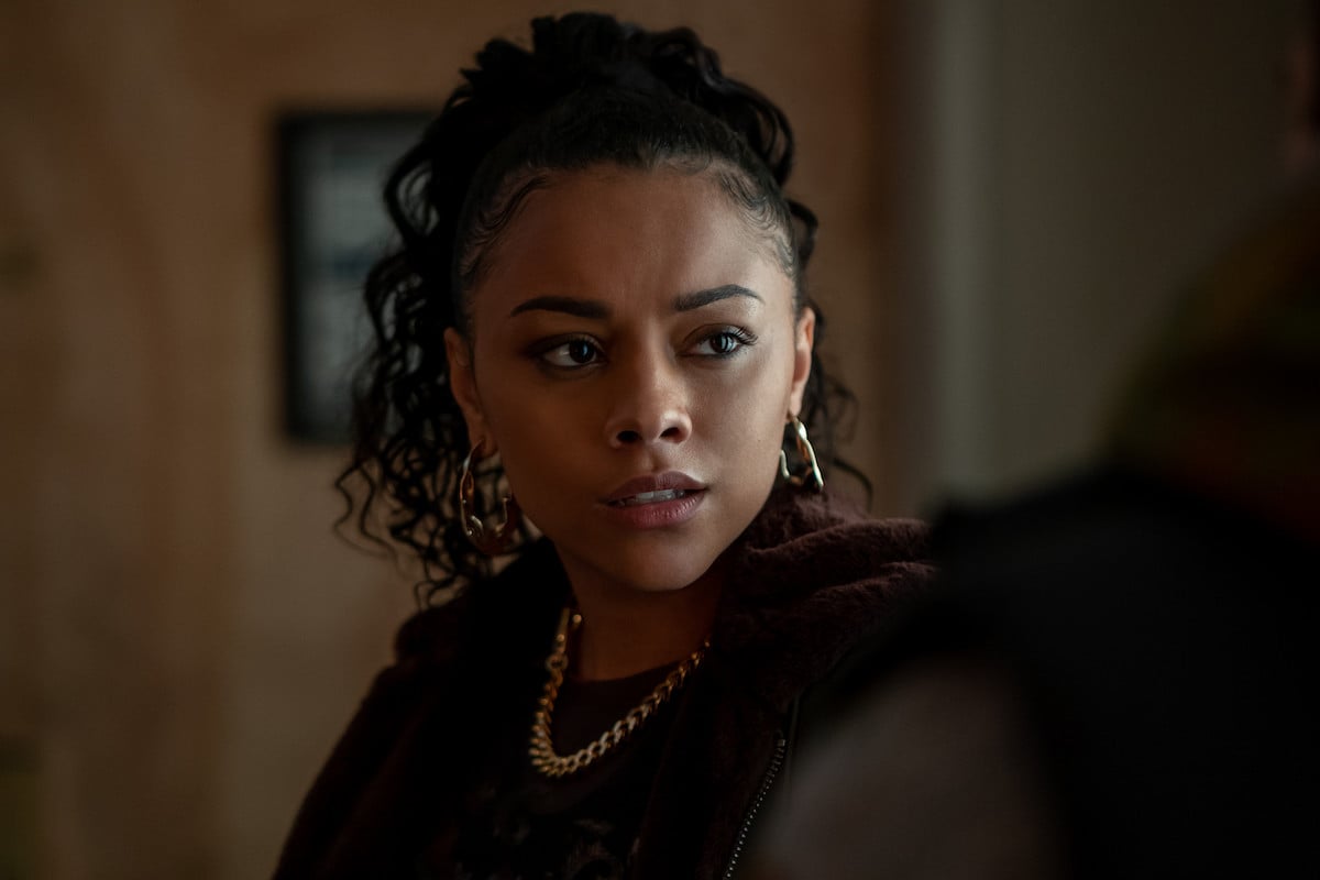 Alix Lapri as Effie Morales in 'Power Book II: Ghost' wearing a black jacket and curly ponytail