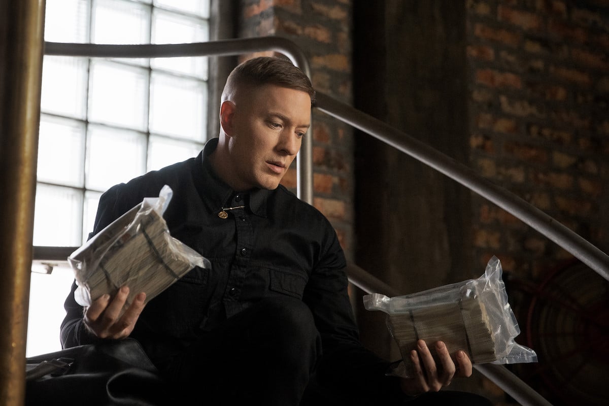 Joseph Sikora as Tommy Egan holding two huge bags of money in 'Power Book IV: Force'