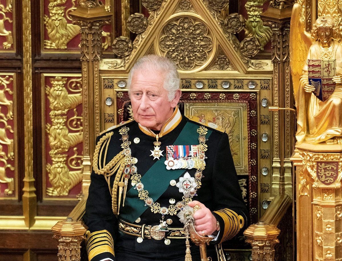 Prince Charles, who will have a toned-down coronation that will still "knock your socks off," sitting in the House of Lords chamber, during the State Opening of Parliament