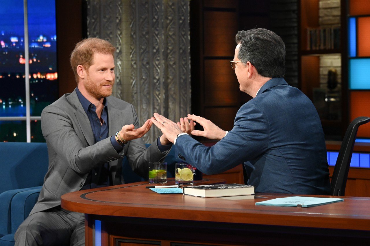 Prince Harry and Stephen Colbert touch hands on The Late Show with Stephen Colbert. 