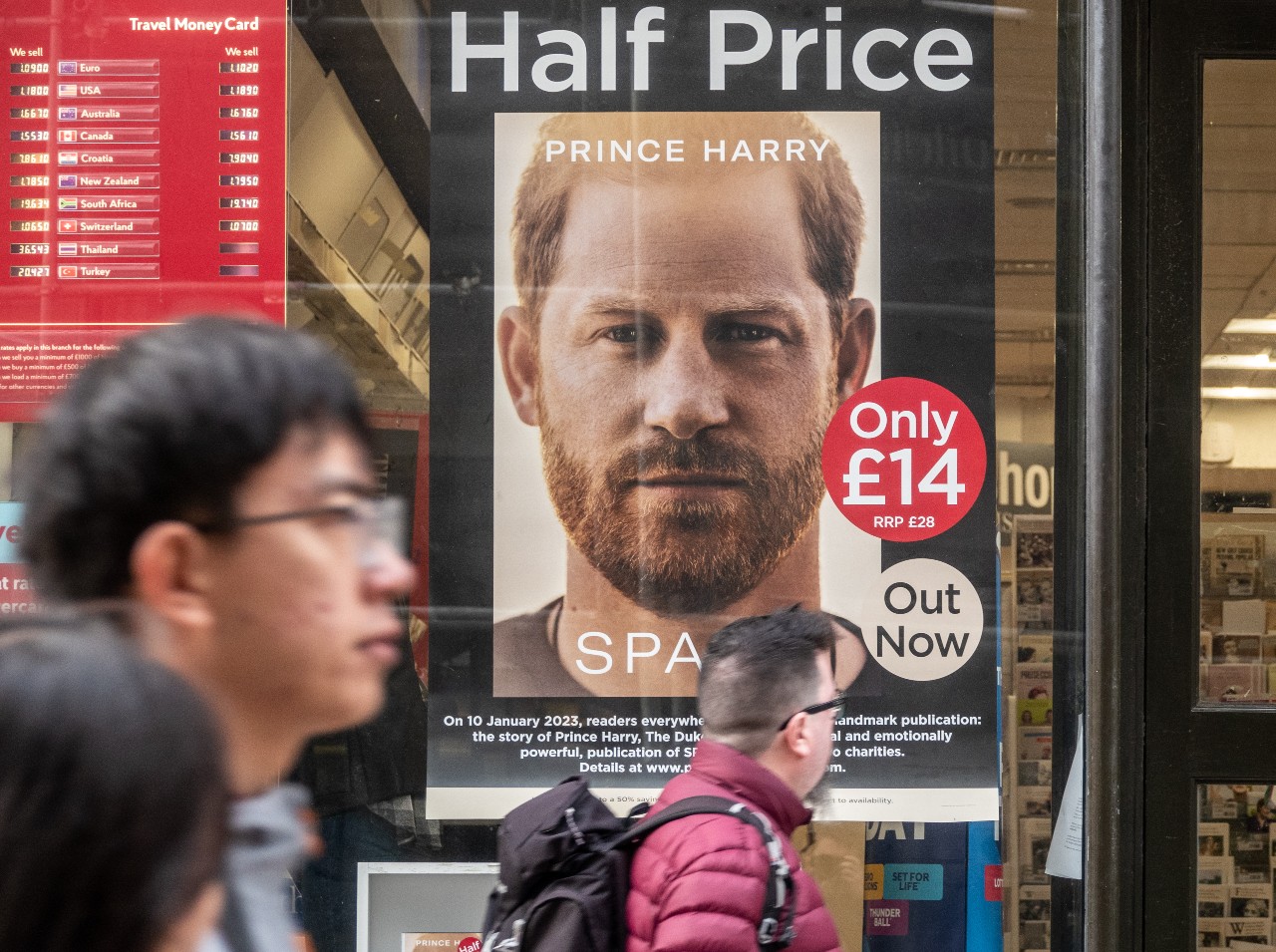 Prince Harry's book cover photo is seen through the window of a bookstore.