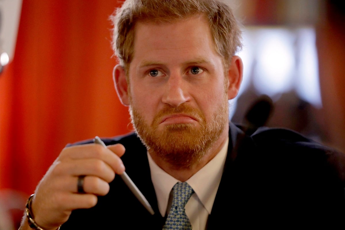 Prince Harry, who a royal photographer said he wanted to 'smack,' frowning during meeting with young people from across the Commonwealth in a roundtable discussion in London