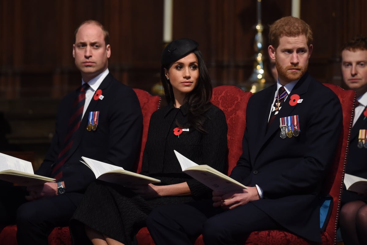 Prince William, whom Prince Harry claimed 'aired his concerns' about Meghan Markle in a conversation he 'doesn't truly understand, sits next to Meghan Markle and Prince Harry