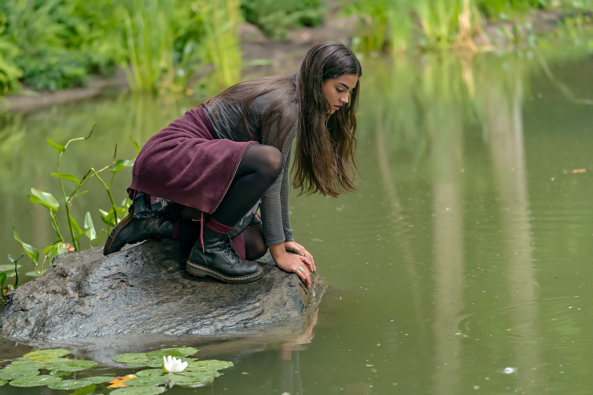 Sadie Laflamme-Snow looking into a pond in 'The Way Home' available to stream on Hallmark movies now