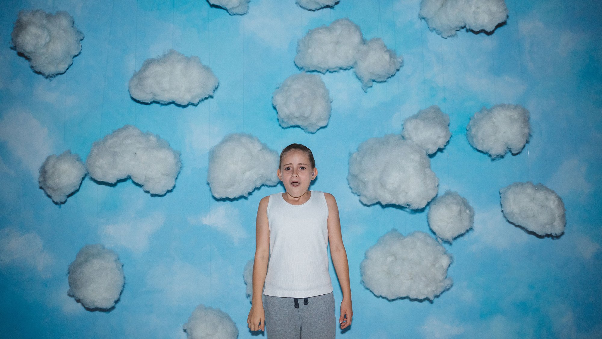 'Scrapper' Lola Campbell as Georgie with her mouth open against a cloud-filled background