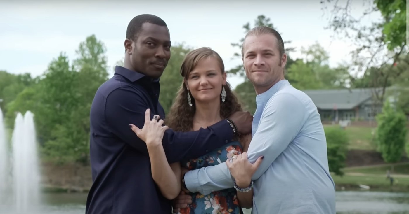 Two men hug a woman as they pose for a photo for promo for TLC's 'Seeking Brother Husband.'