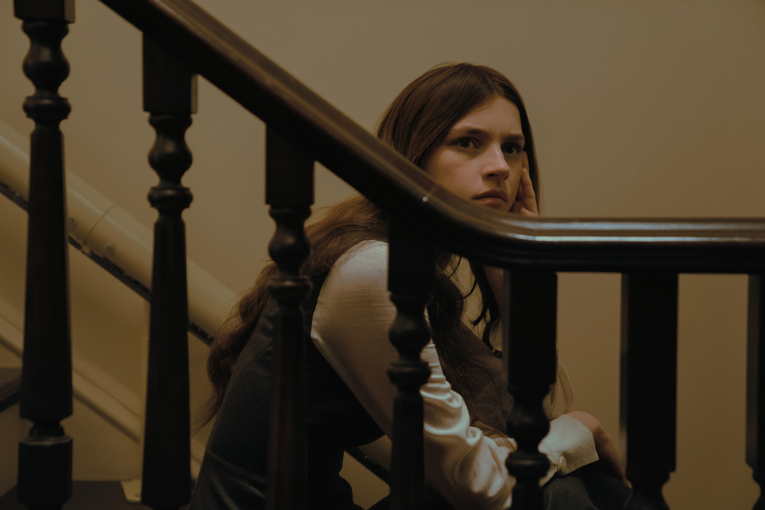 'Servant' Season 4 character Leanne, played by Nell Tiger Free, sits on a staircase looking over the railing.