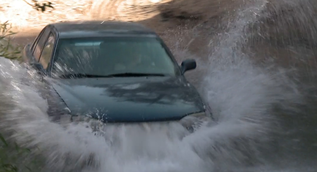 Christine Brown driving a car through a creek in 'Sister Wives' Season 3 on TLC.