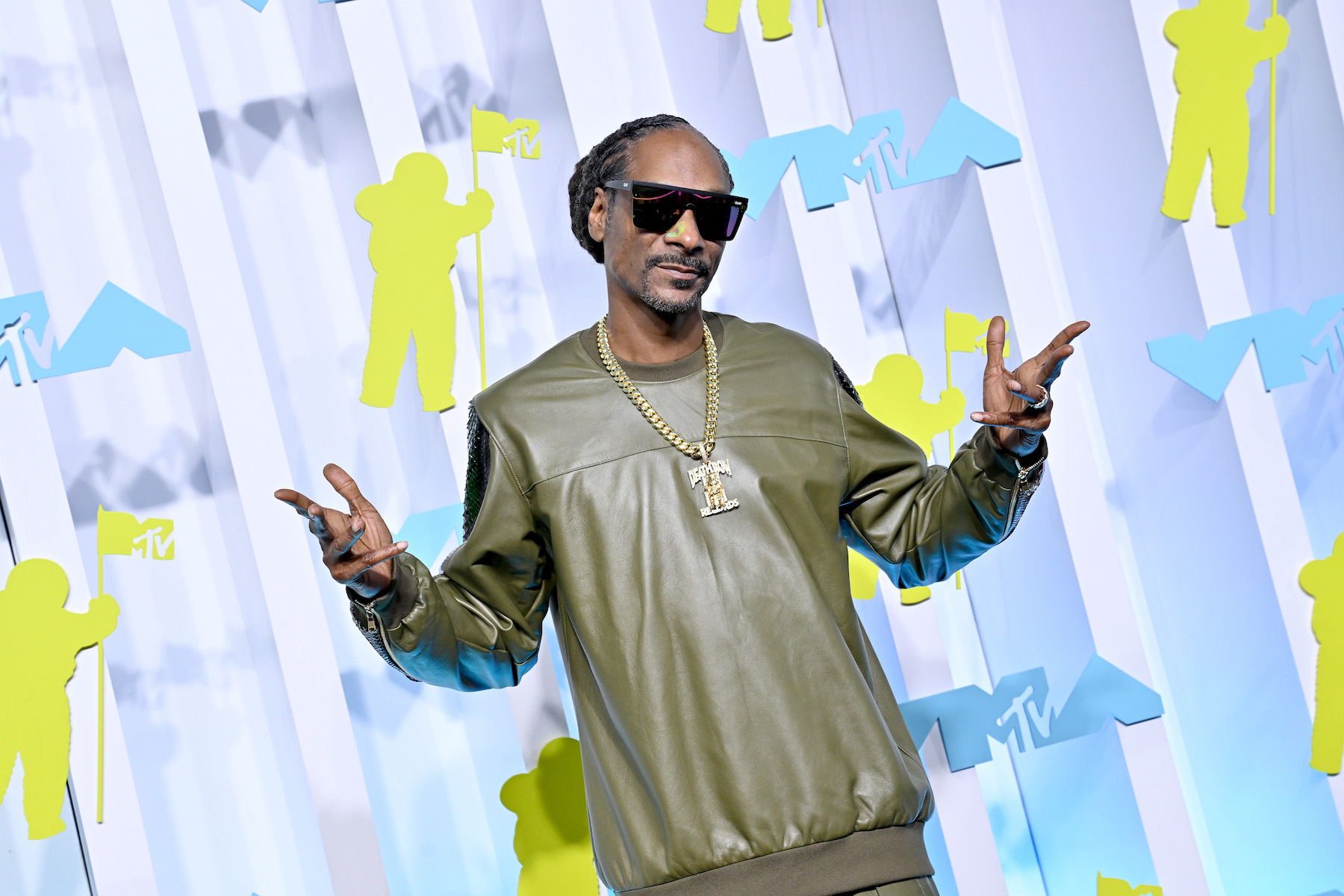Funko Pop face Snoop Dogg posing for a photo wearing a green sweater