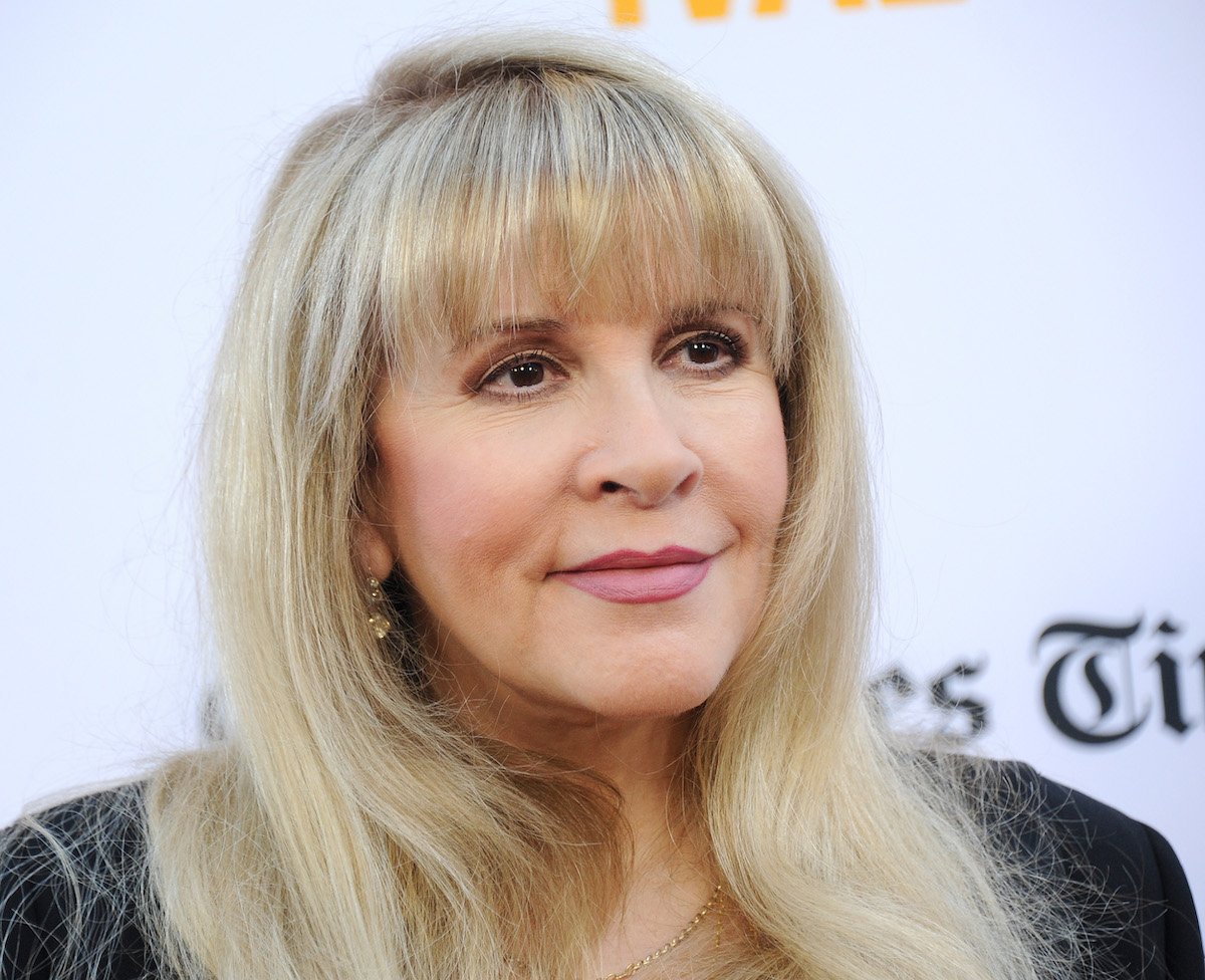 Stevie Nicks smiles and poses at an event.