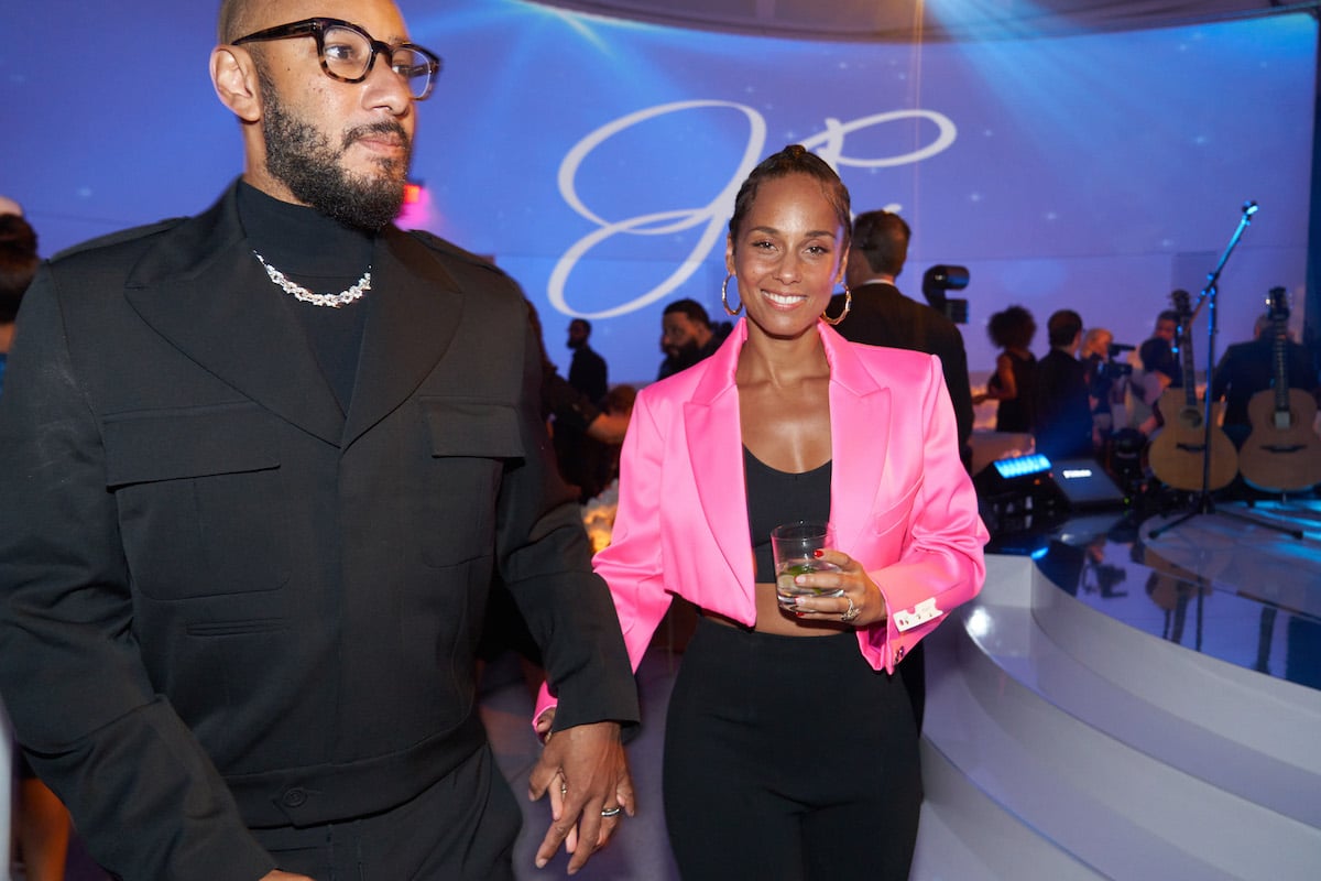 Swizz Beats and Alicia Keys hold hands at a 2022 event