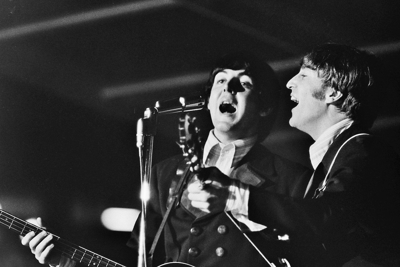 Paul McCartney and John Lennon performing with The Beatles on tour in 1966.