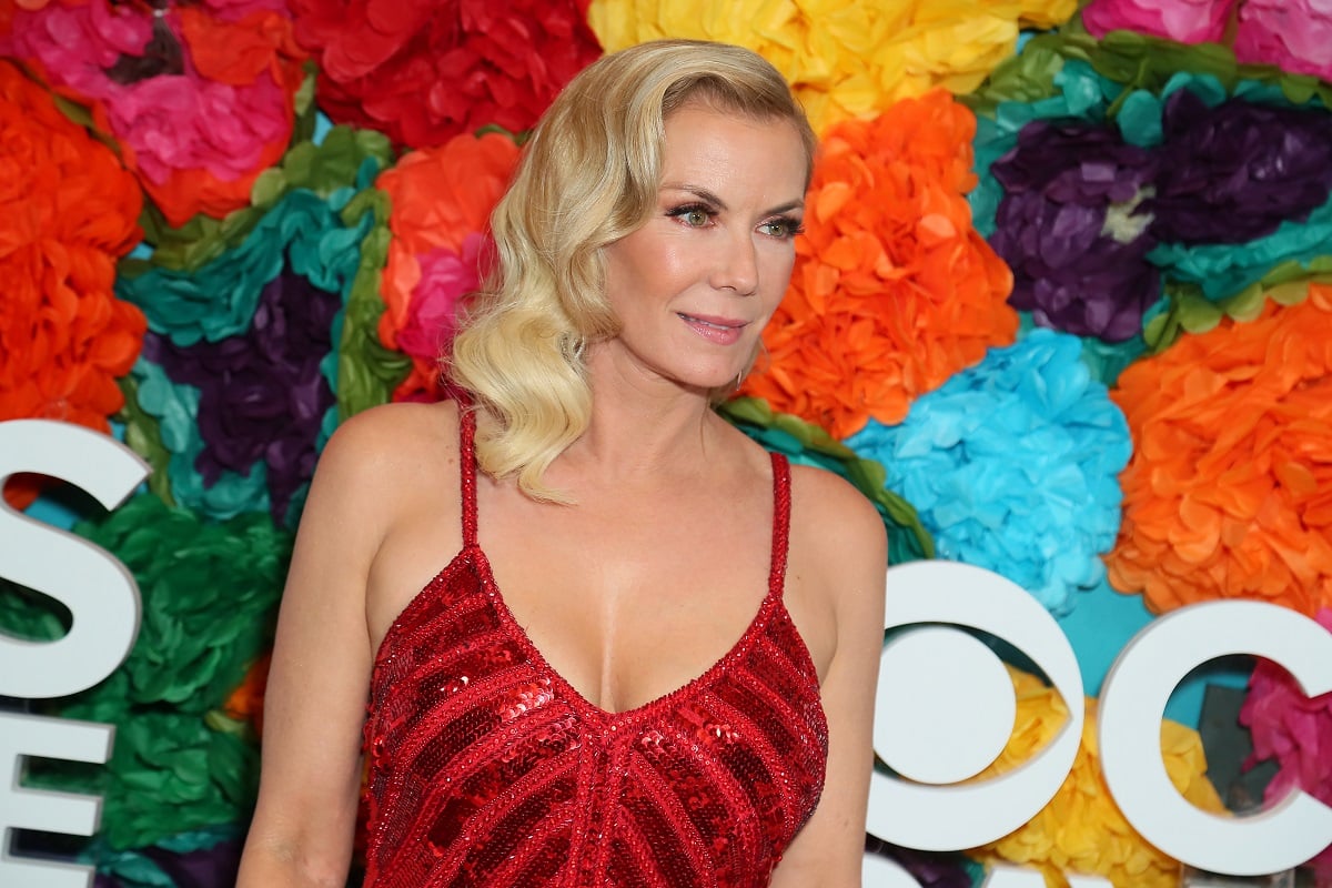 'The Bold and the Beautiful' star Katherine Kelly Lang wearing a red dress and posing in front of a floral hedge.