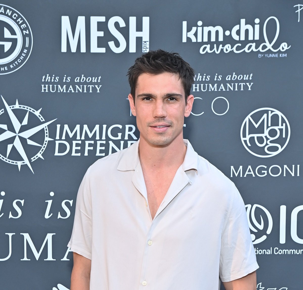 'The Bold and the Beautiful' star Tanner Novlan wearing a white shirt and smiling during a red carpet appearance.