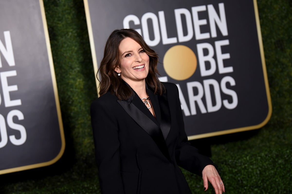 Actor Tina Fey wearing a black suit walks the carpet of the 2021 Golden Globe Awards.