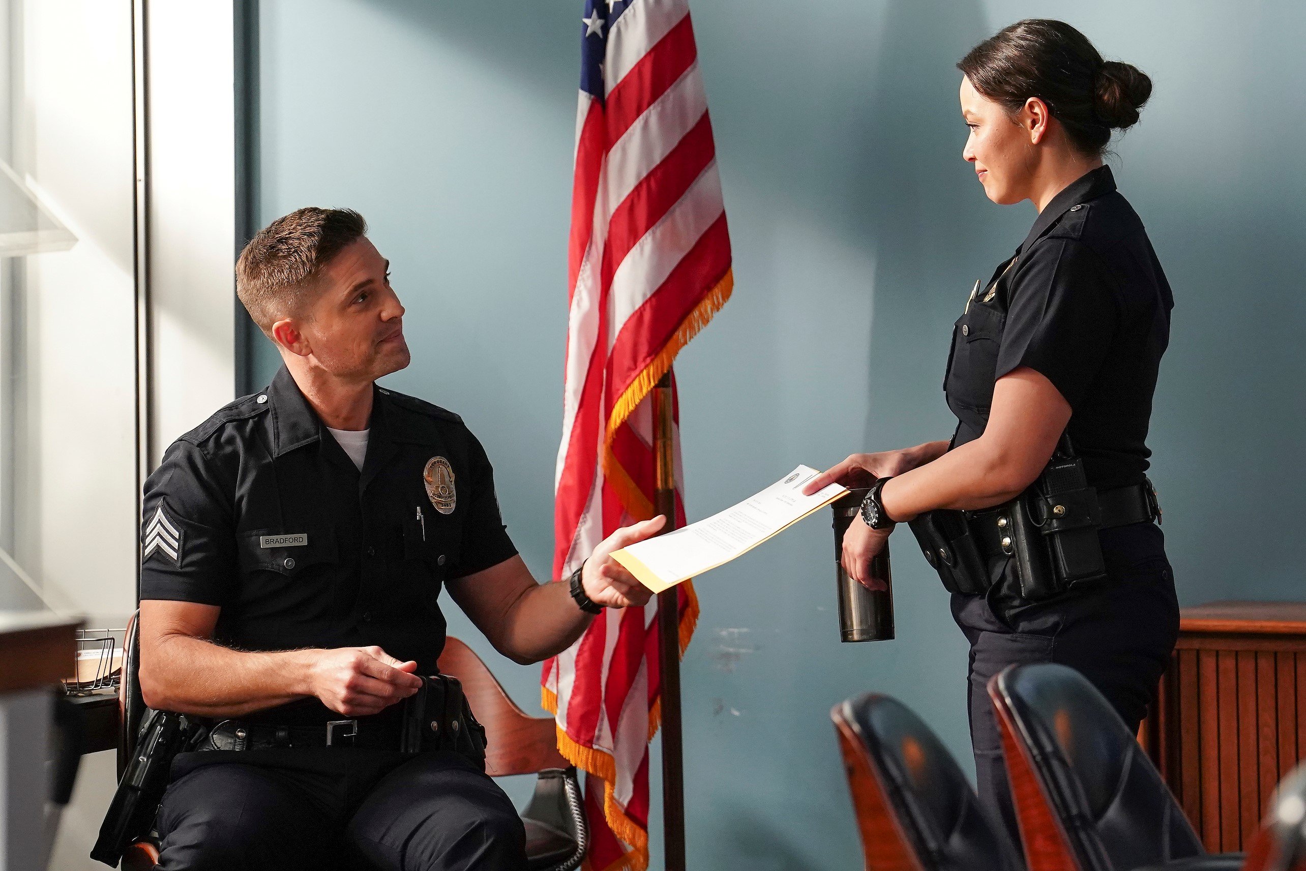 Eric Winter and Melissa O'Neil, in character as Tim Bradford and Lucy Chen, share a scene wearing their cop uniforms in 'The Rookie' Season 5 Episode 13 on ABC.