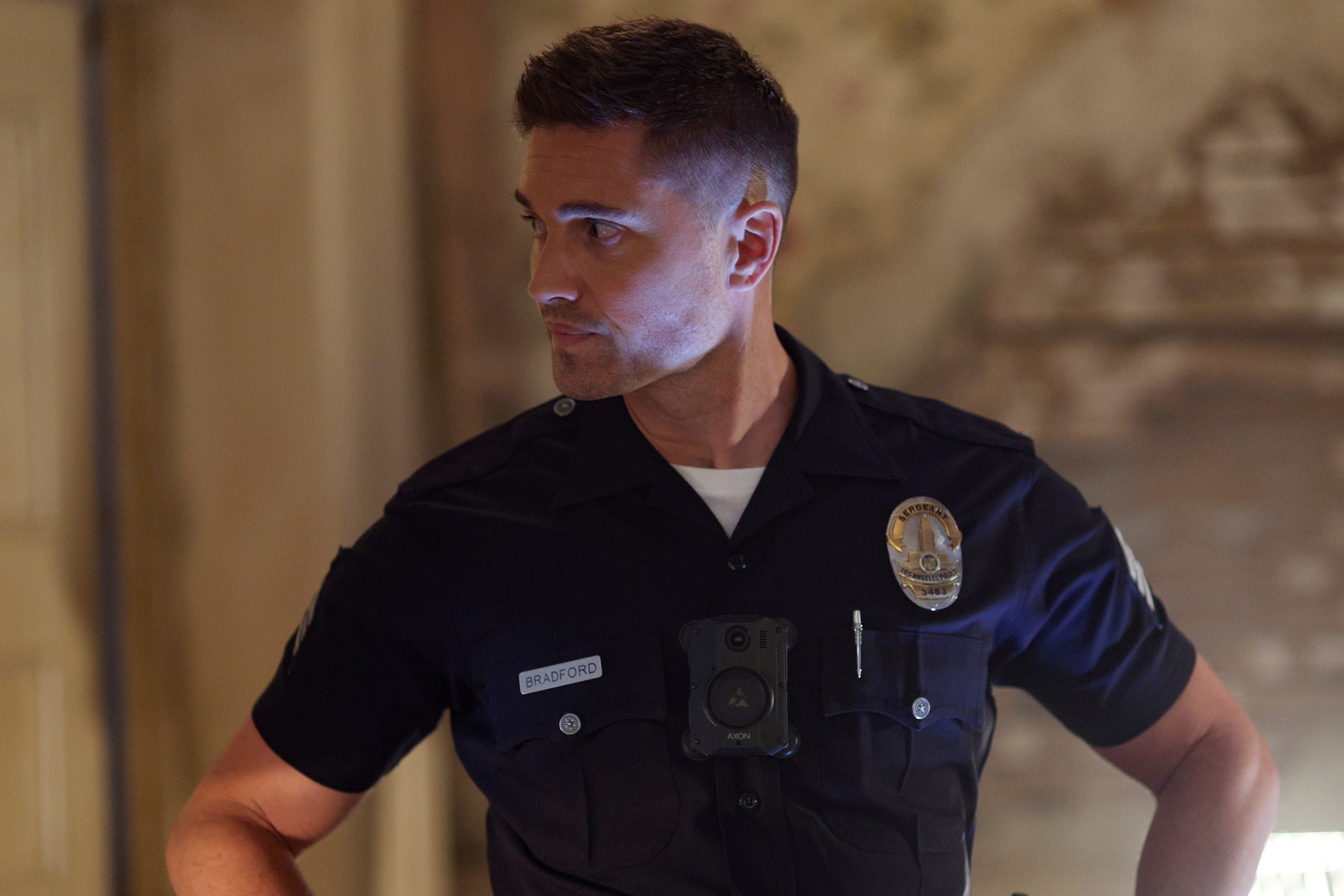 Eric Winter, in character as Tim Bradford in 'The Rookie' Season 5, wears his dark blue cop uniform.