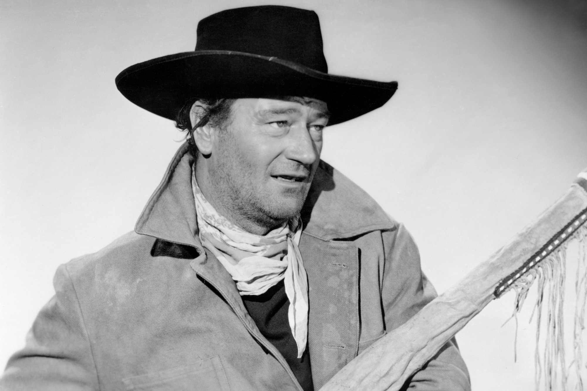 'The Searchers' John Wayne as Ethan Edwards wearing a cowboy outfit and holding a gun