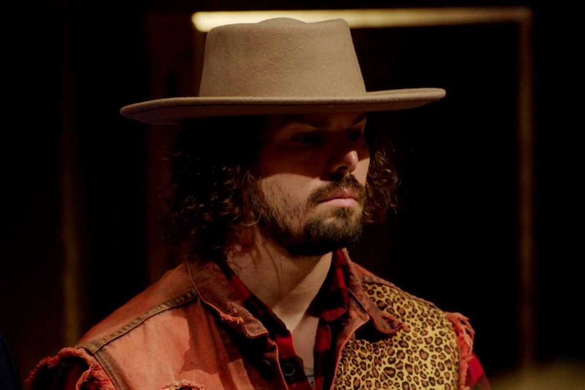 Christian De La Torre, who stars in 'The Traitors' on Peacock, wears a tan wide-brimmed hat and a red and leopard print jacket.