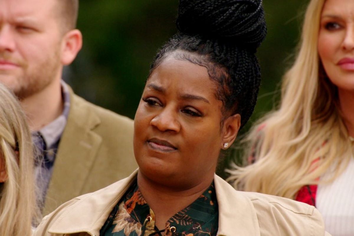 Cirie Fields, who stars in 'The Traitors' on Peacock, wears a tan jacket over a dark green, orange, and yellow floral shirt.