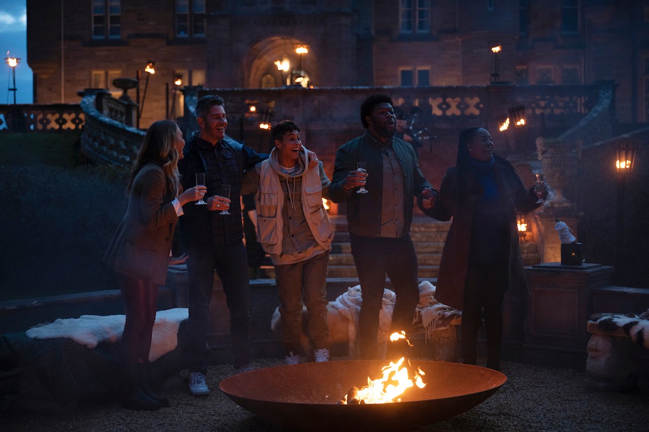 Kate Chastain, Arie Luyendyk Jr., Andie Thurmond, Quentin Jiles, Cirie Fields stand around a fire pit looking shocked on 'The Traitors'.