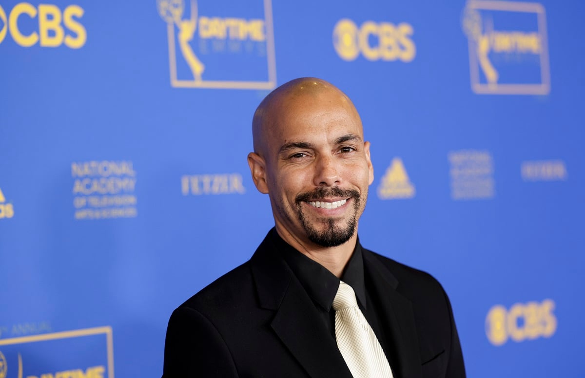 'The Young and the Restless' star Bryton James wearing a black suit and white; smiles on the red carpet of the 2022 Daytime Emmys.