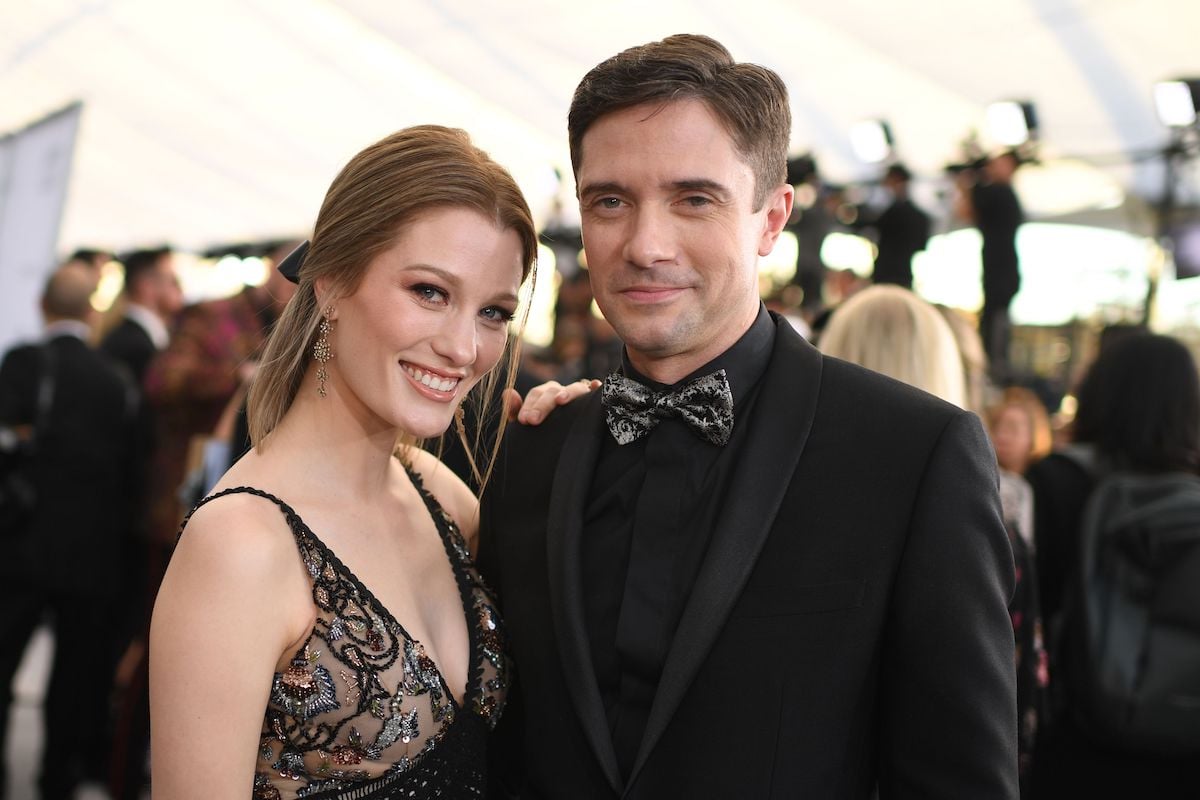 Actor Topher Grace and his wife actress Ashley Hinshaw walk a red carpet in 2019