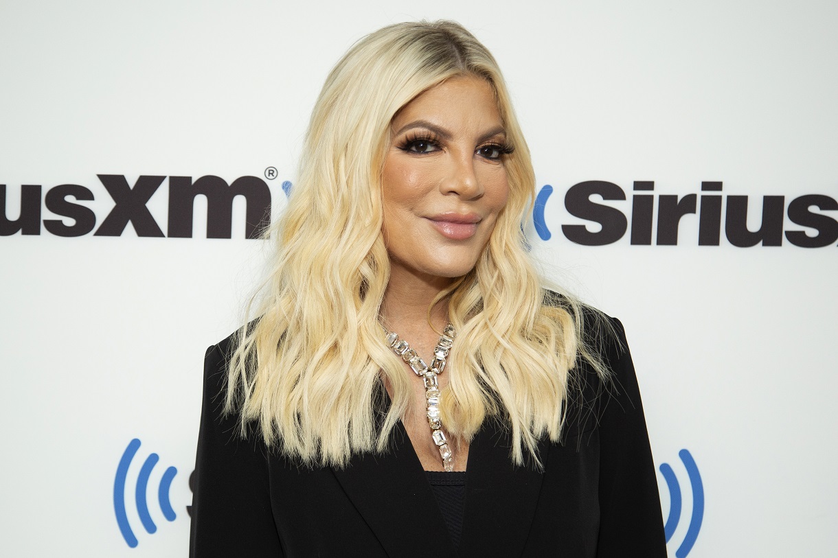 Tori Spelling stands in front of a SiriusXM backboard while appearing at the Studio in 2022