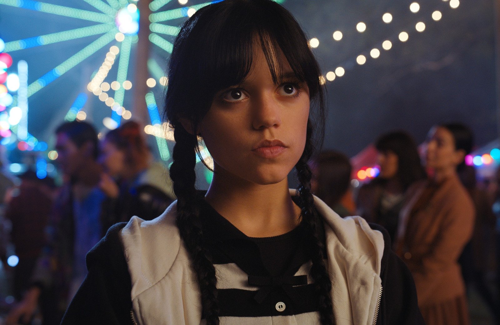 Jenna Ortega as Wednesday Addams in 'Wednesday,' which was renewed for season 2 on Netflix. Her hair is in double braids, and she's frowning at someone.