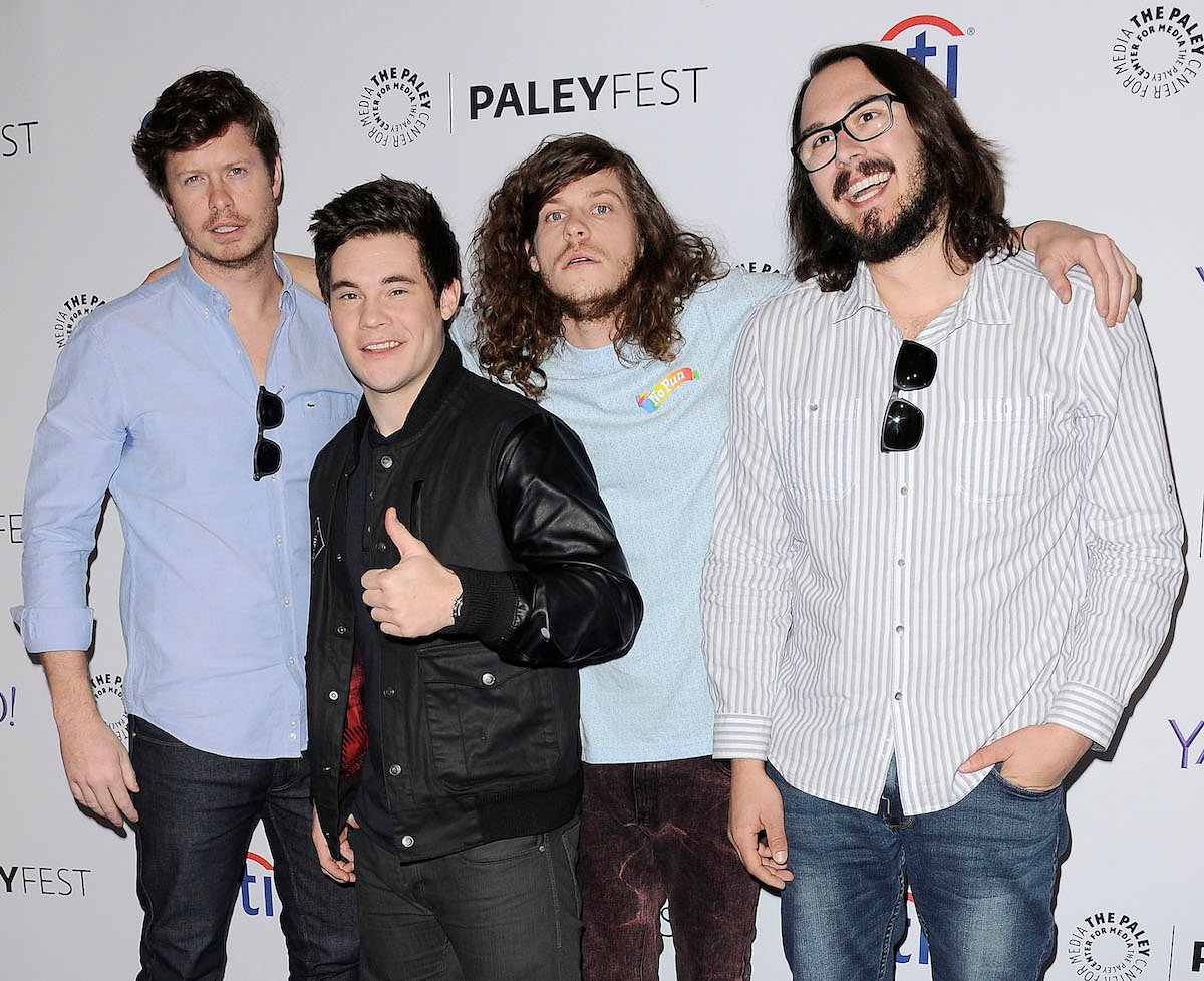 The cast of "Workaholics" pose in front of a black and white backdrop at an event in 2015.