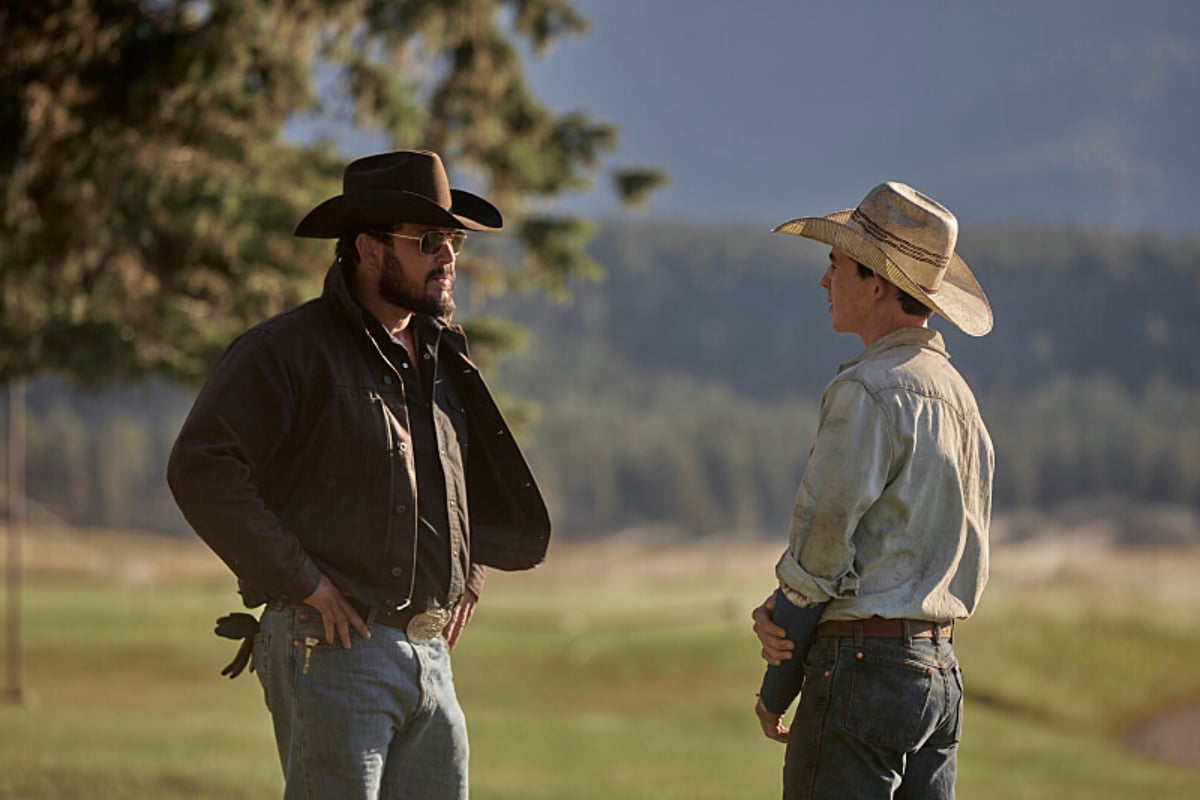 Cole Hauser and Finn Little as Rip and Carter in Yellowstone talk outside at the ranch.