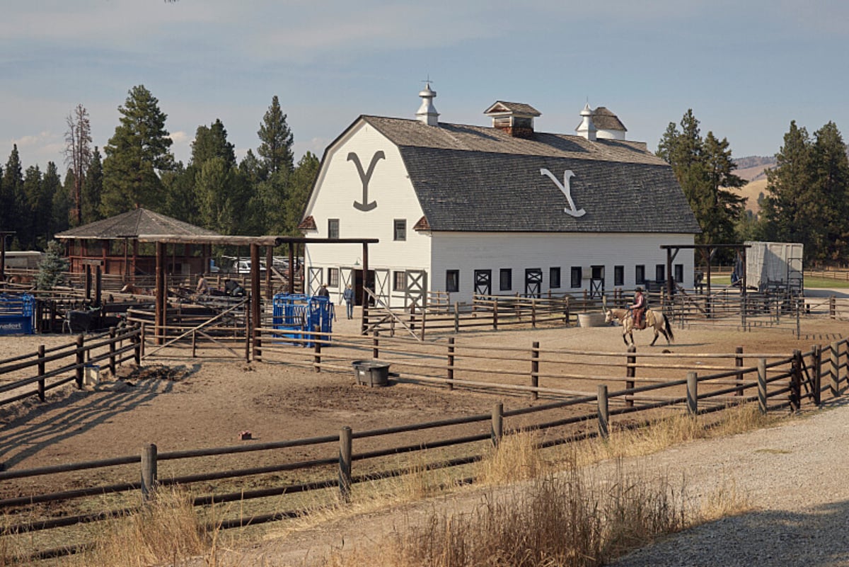 The Yellowstone Season 5 midseason finale was dedicated to Dr. Glenn Blodgett. Someone rides a horse in front of a barn at the Yellowstone Dutton Ranch.