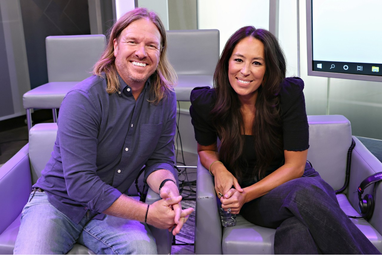 Chip and Joanna Gaines sit next to each other and smile.