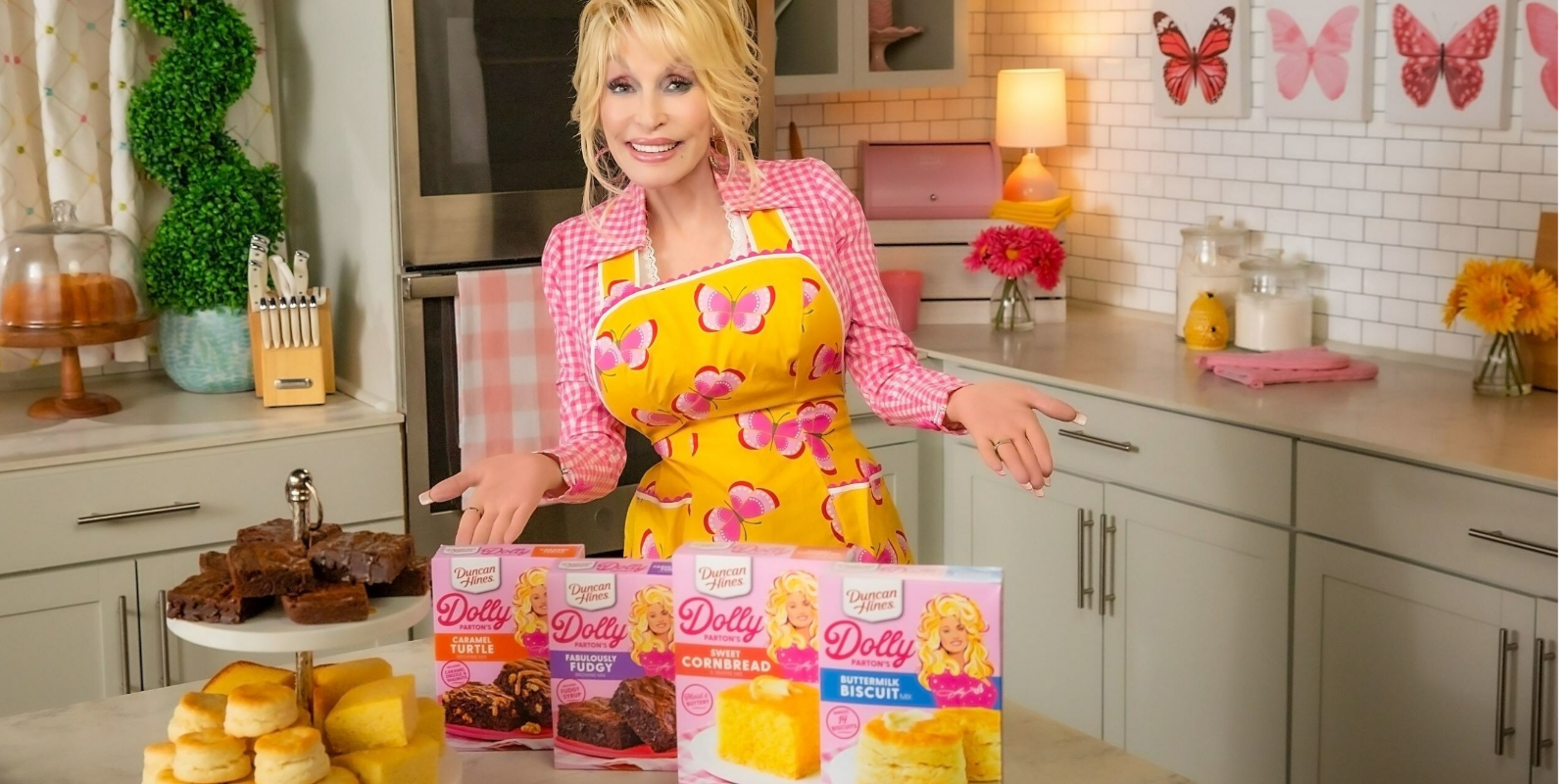 Dolly Parton poses with her newest lines of baking mixes in collaboration with Duncan Hines.