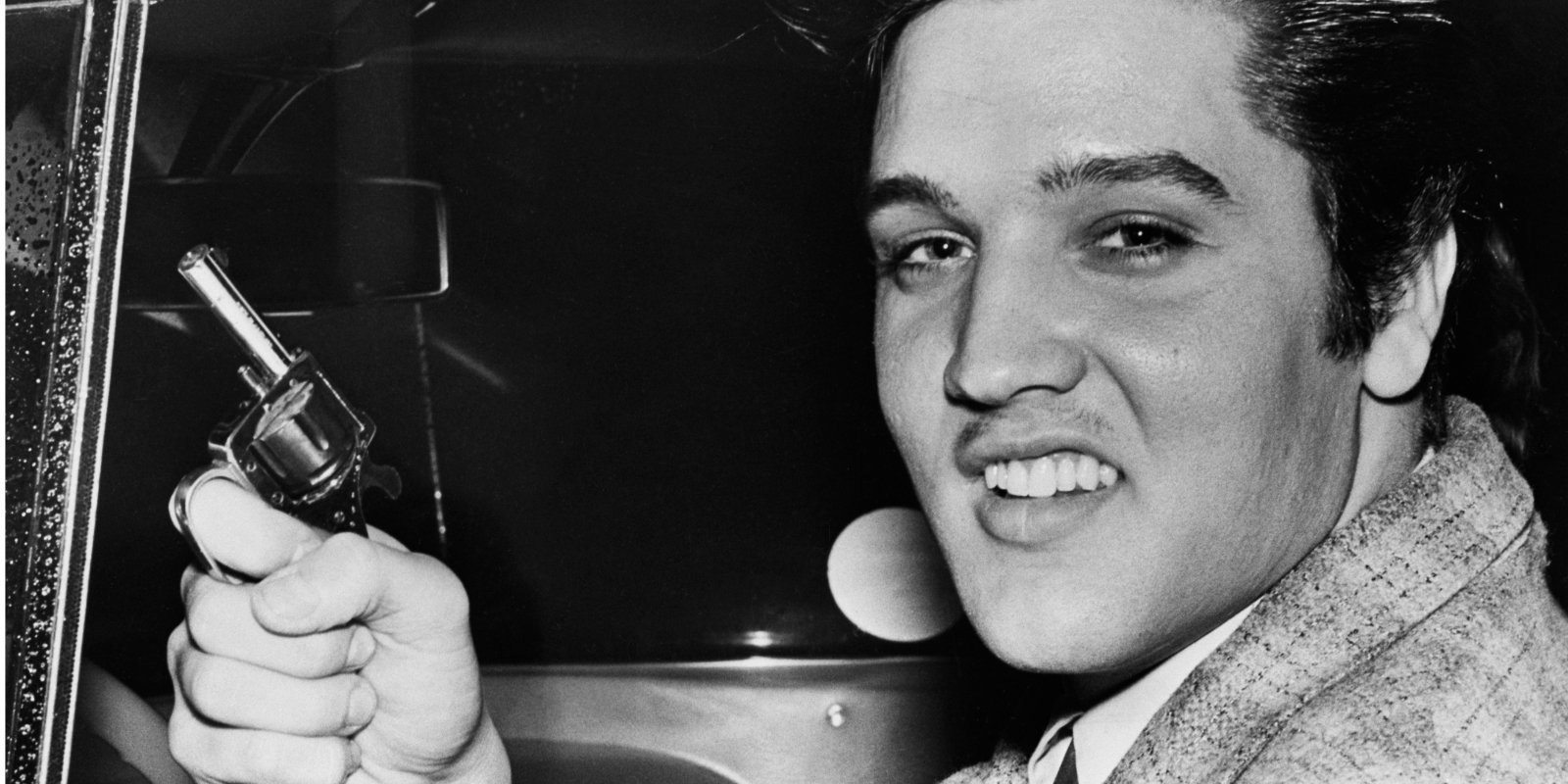 Elvis Presley held a toy pistol in 1957.