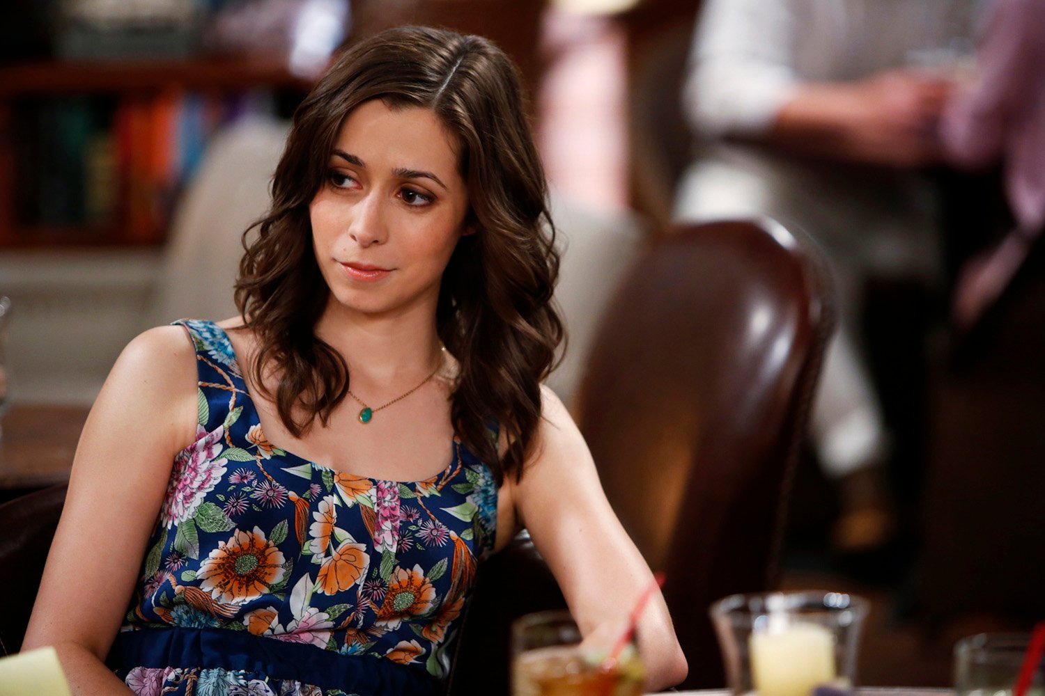Cristin Milioti as Tracy sitting at a table and looking off to the side in How I Met Your Mother