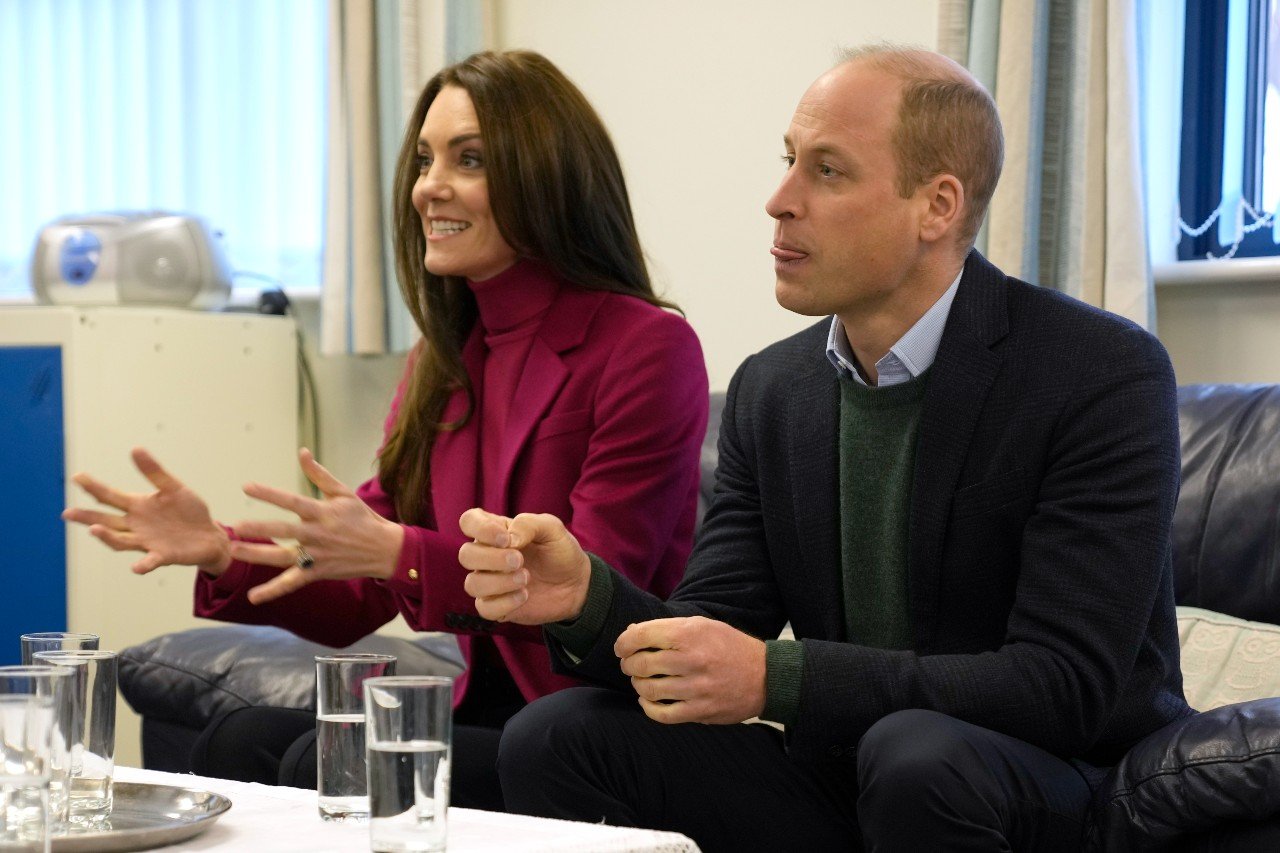 Kate Middleton and Prince William sit next to each other during an event. 