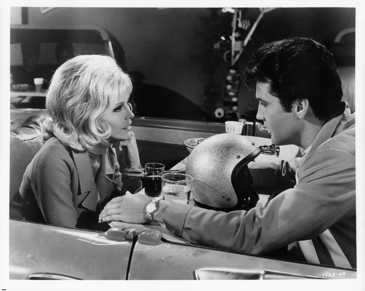 Nancy Sinatra and Elvis Presley eat in the car together in a scene from the film 'Speedway'