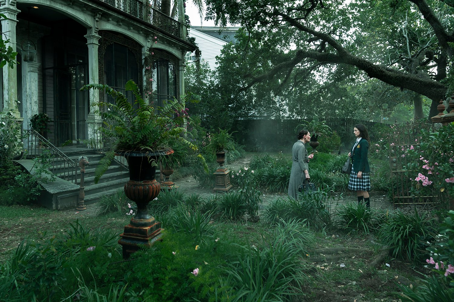 Mayfair Witches: Beth Grant as Carlotta Mayfair and Cameron Jade Inman as Young Deirdre Mayfair standing in the garden outside the historic home where Mayfair Witches was filmed.