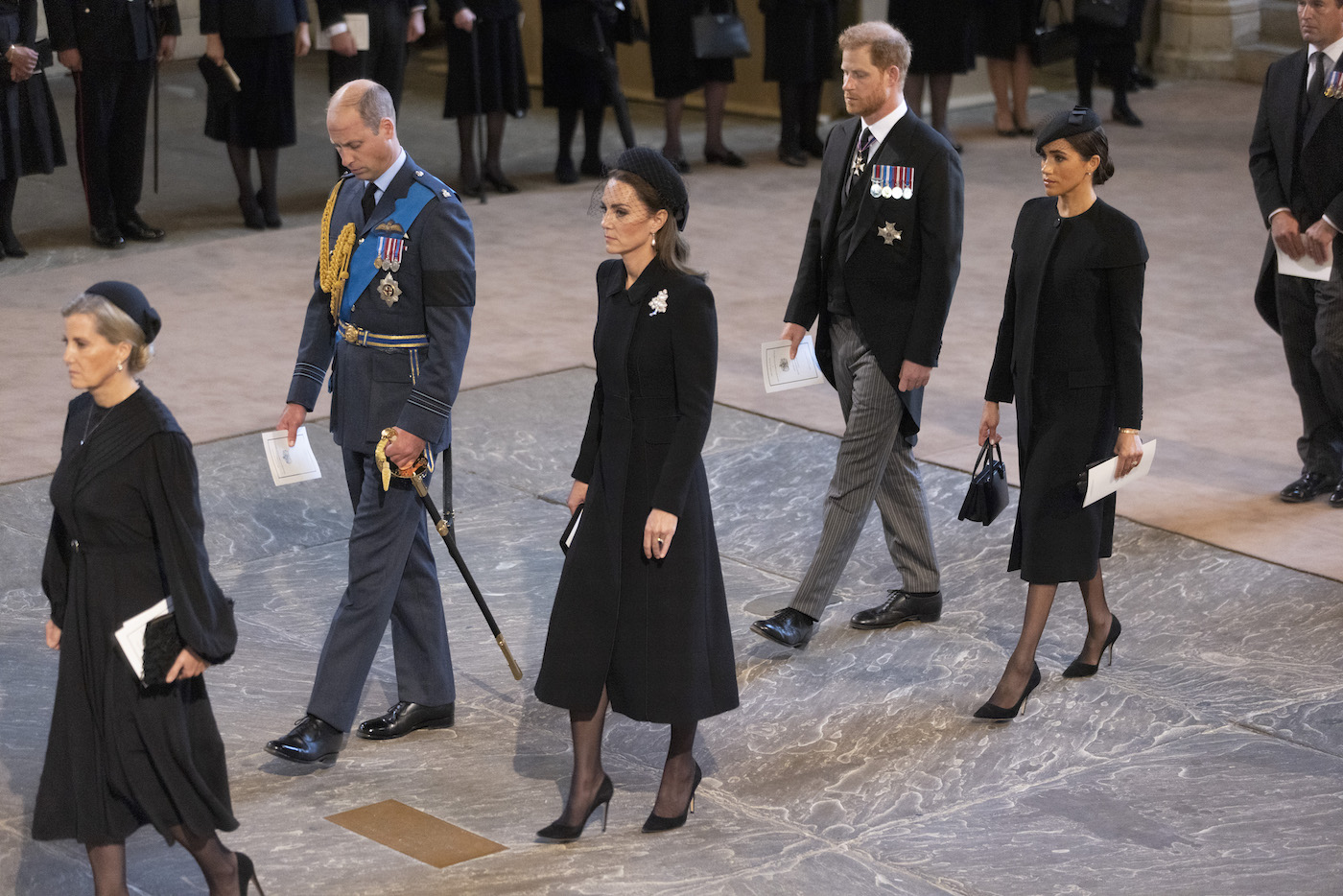 Prince William, Prince of Wales, Catherine, Princess of Wales, Harry, Duke of Sussex and Meghan, Duchess of Sussex walk behind the casket at the late Queens funeral 